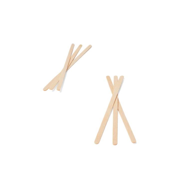 Holzrührstäbchen nebeneinander gelegt auf weißem Hintergrund