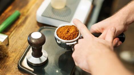 Kaffee wird durch Tapping mit den Fingern im Tamper verteilt