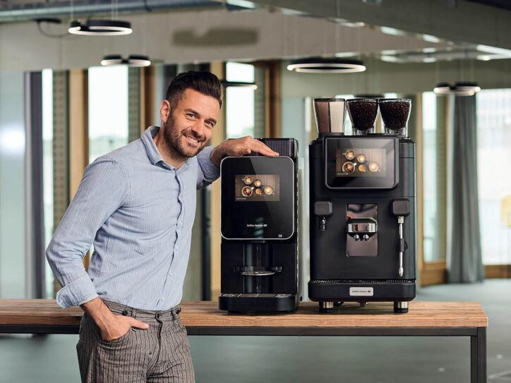 Junger Mann präsentiert die Modelle Barista Select und Barista Ultima