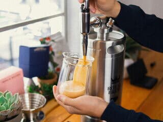 Nitro Coffee wird aus Zapfhahn eines Getränkesystems frisch ins Glas gezapft