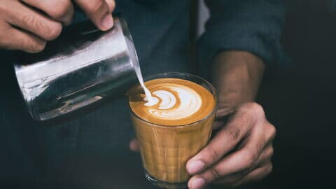 Barista mach Latte Art im Glas