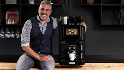 Roland Trettl mit Kaffeevollautomat von Kaffee Partner