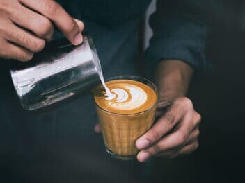Barista mach Latte Art im Glas