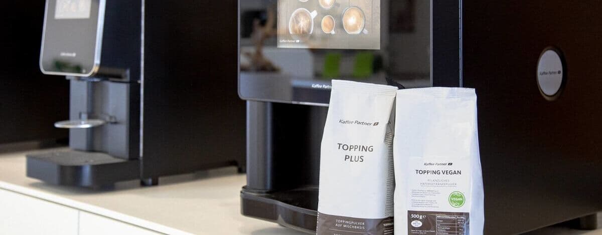 Topping-Packungen neben Kaffeevollautomat
